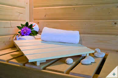 Interno sauna combinata finlandese e infrarossi per casa: panche in legno, vetro bronzato, illuminazione