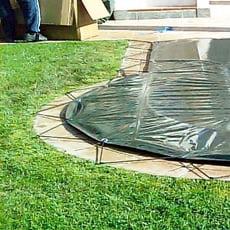 Copertura invernale con occhielli e cavo elastico per piscina a forma libera - 210 g/mq